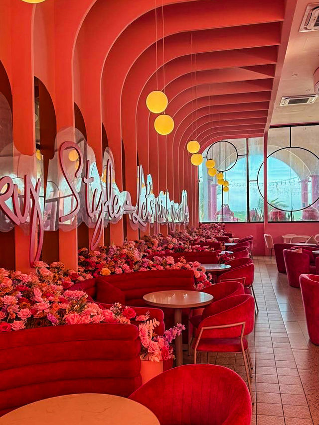 Pink fairytale cafe interior with floral walls and hanging swing