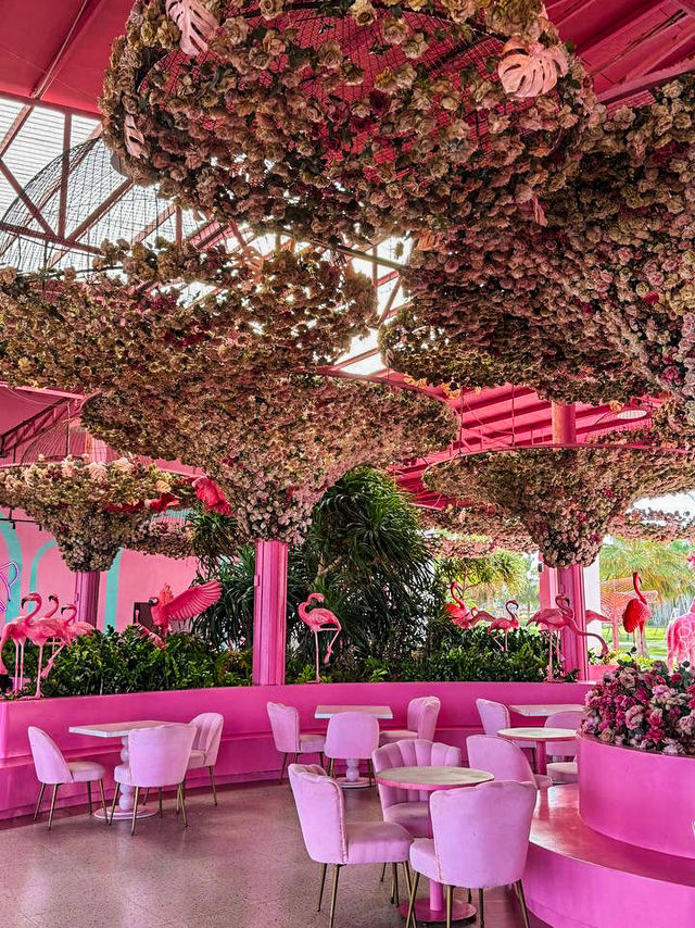 Pink neon sign and artificial flowers at pink fairytale cafe
