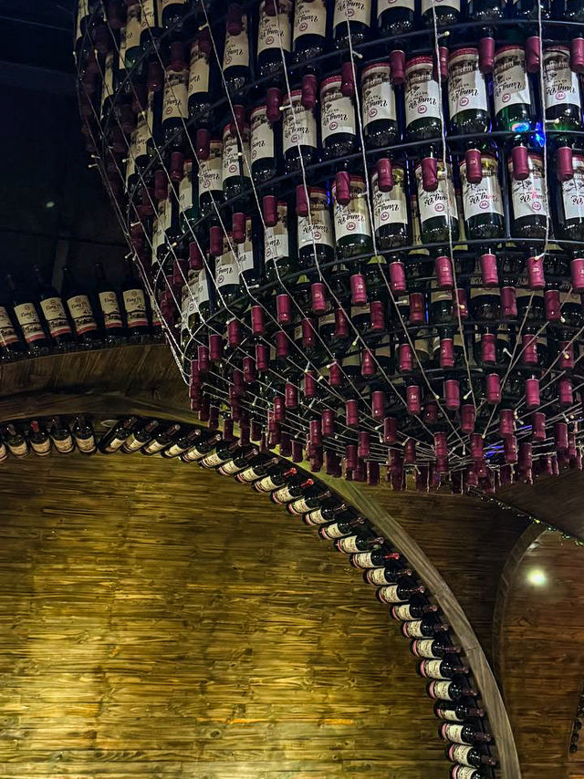 Underground wine cellar tunnel lined with bottles at lost hobbit village vietnam