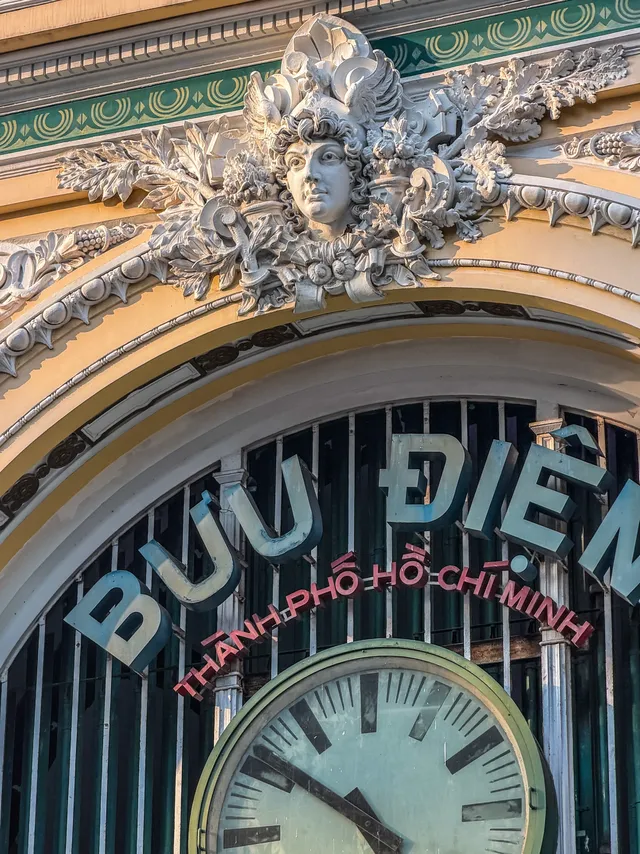 Bright yellow facade of Saigon Central Post Office with arched windows