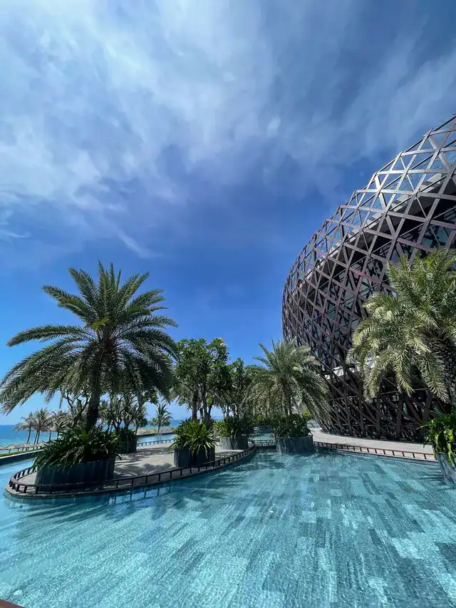 Axi Beach Lounge Cam Ranh green lawn area between pools and long sandy beach