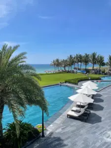 Freshwater pool surrounded by green lawn at Axi Beach Lounge Cam Ranh