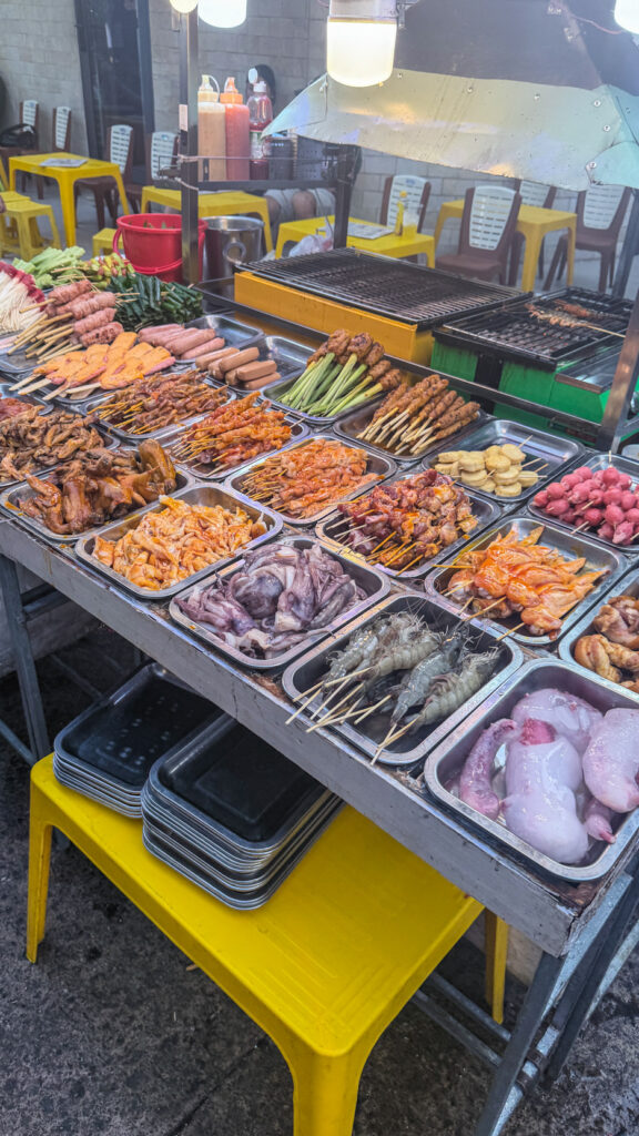Hồ Thị Kỷ street food alley with grilled chicken and vendors beside the flower market Saigon