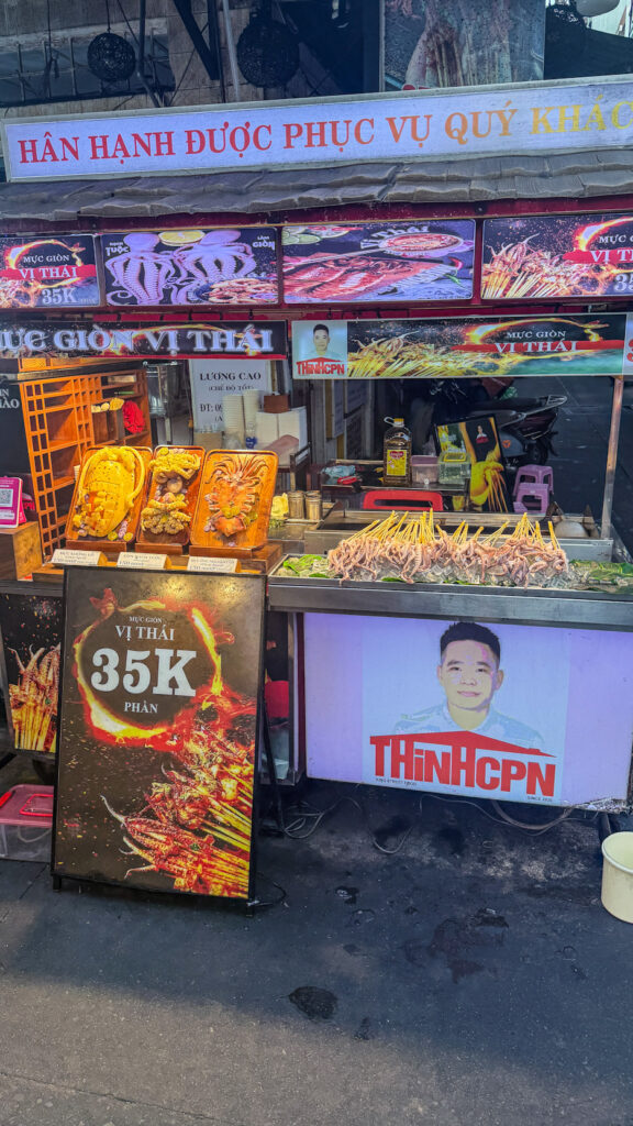 Hồ Thị Kỷ street food alley with grilled chicken and vendors beside the flower market Saigon