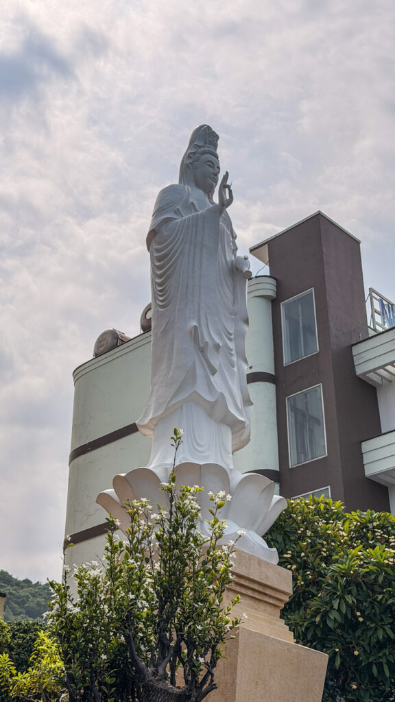 Buddhist temple courtyard with statues and religious decorations
