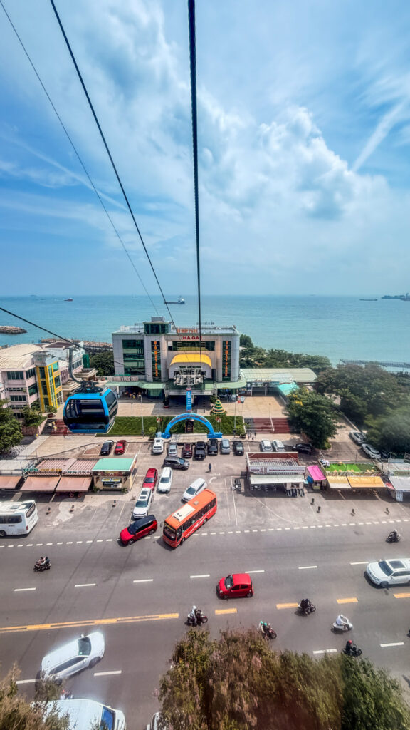 Hồ Mây cable car rising above Vung Tau with the city and sea below
