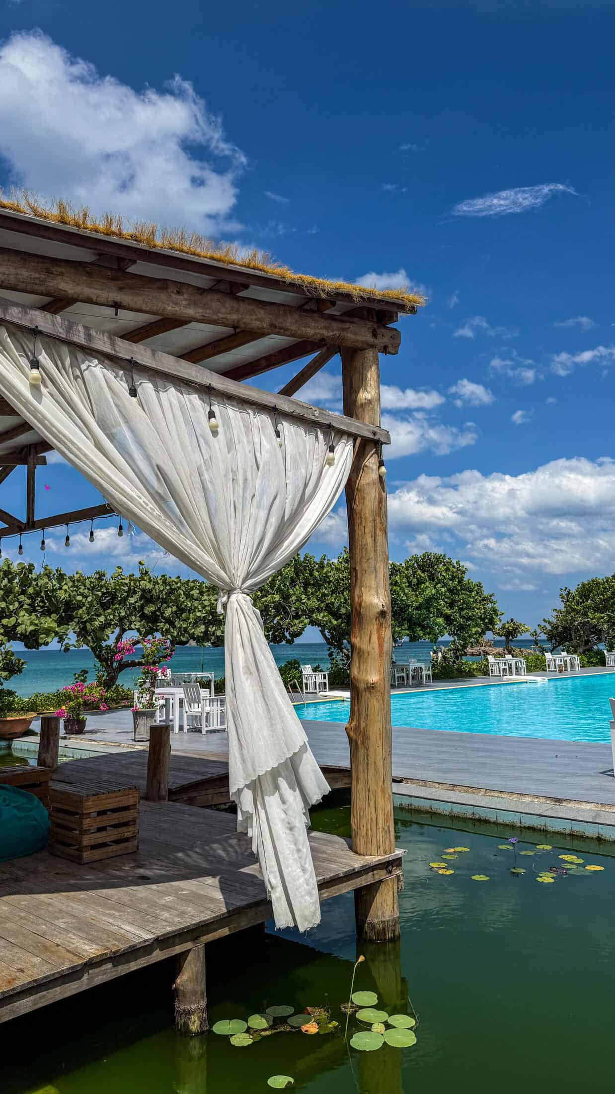 Thatched-roof cabana beside the pool and lily pond at Ana Resort Phu Yen