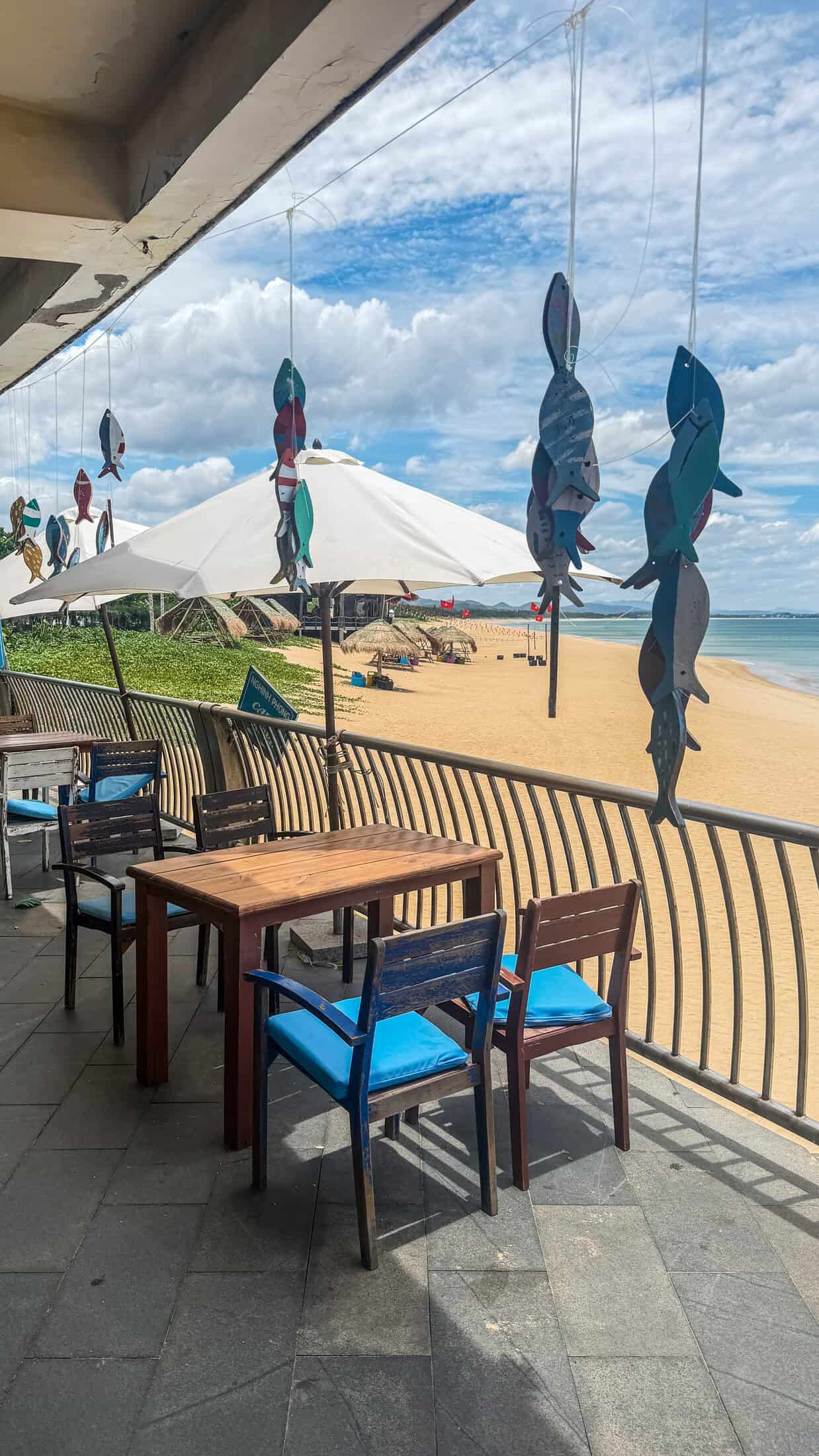 Balcony terrace overlooking the beach with hanging fish decorations at Cafe Thap Nghinh Phong