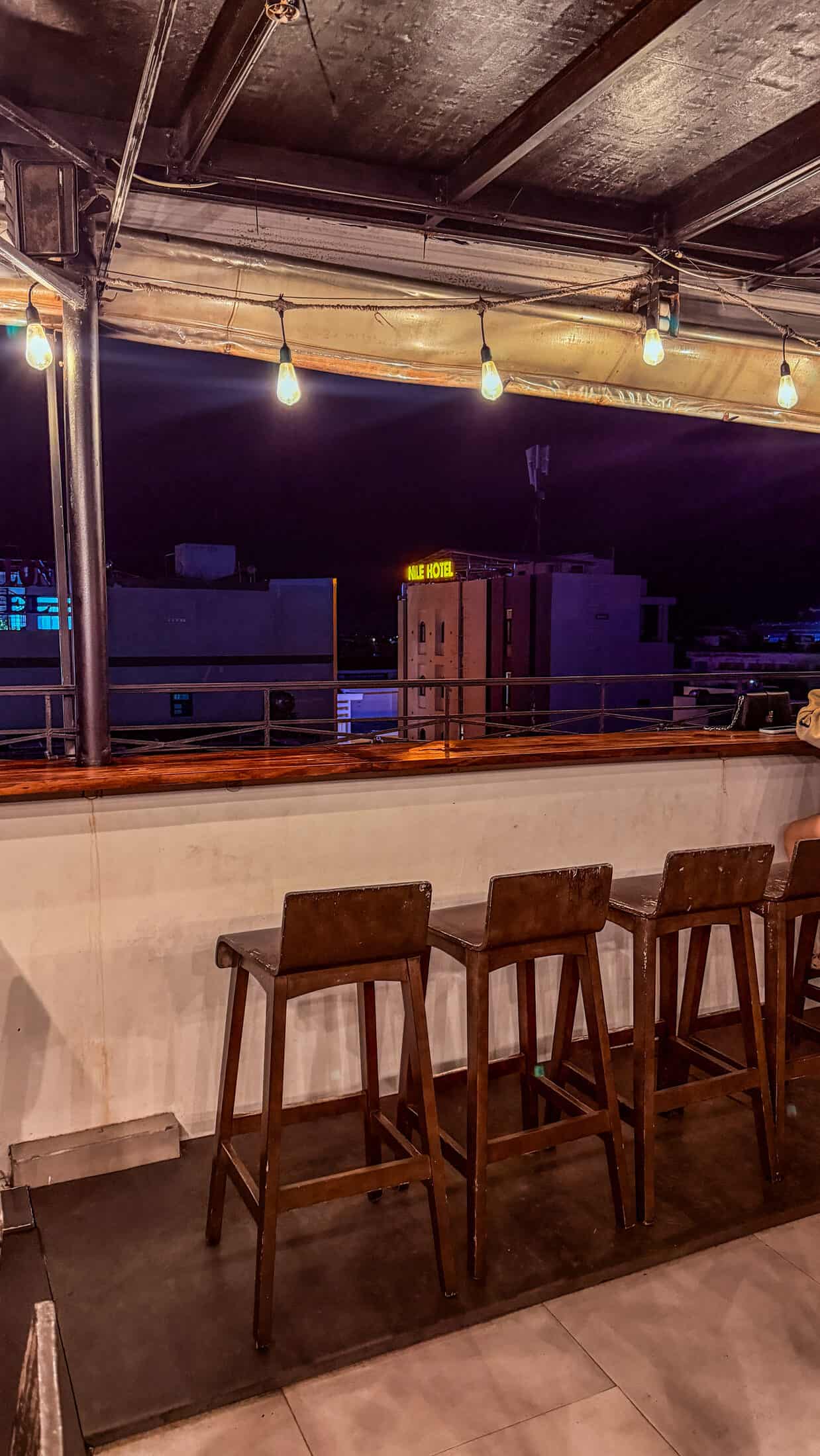 Bar stools along the railing at Coconut Rooftop at night, Tuy Hoa