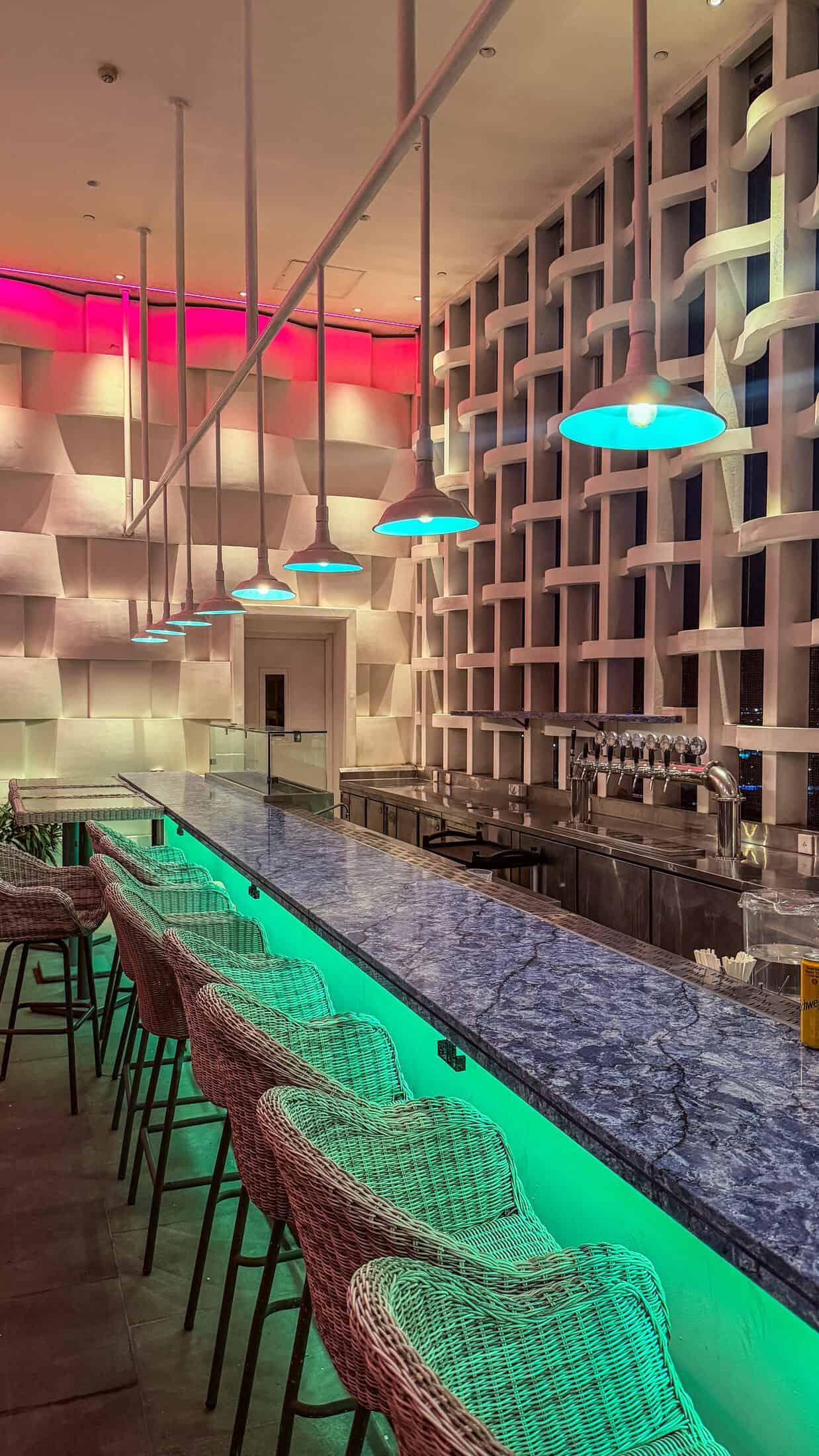 Illuminated marble bar counter with rattan stools at Endless Summer Rooftop Pool and Bar, Tuy Hoa