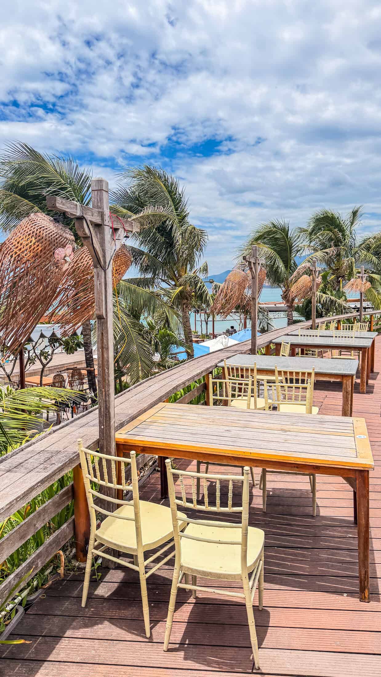 Raised wooden dining deck with a sea view at Bốn Mùa (Four Seasons), Quy Nhon