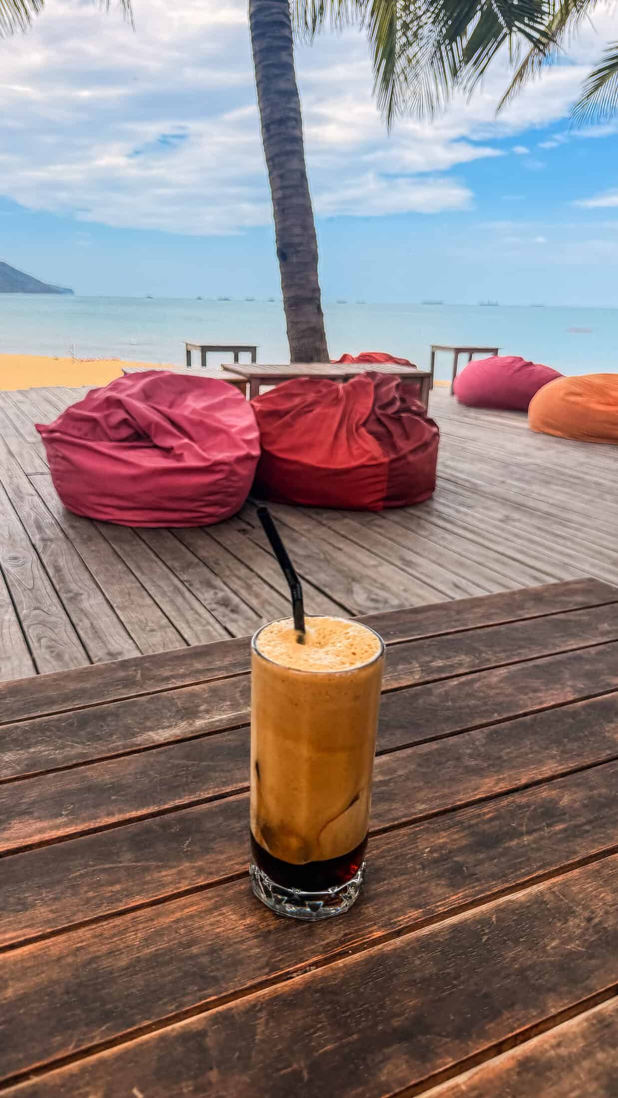 Iced coffee on the table with bean bag loungers at Bốn Mùa (Four Seasons), Quy Nhon