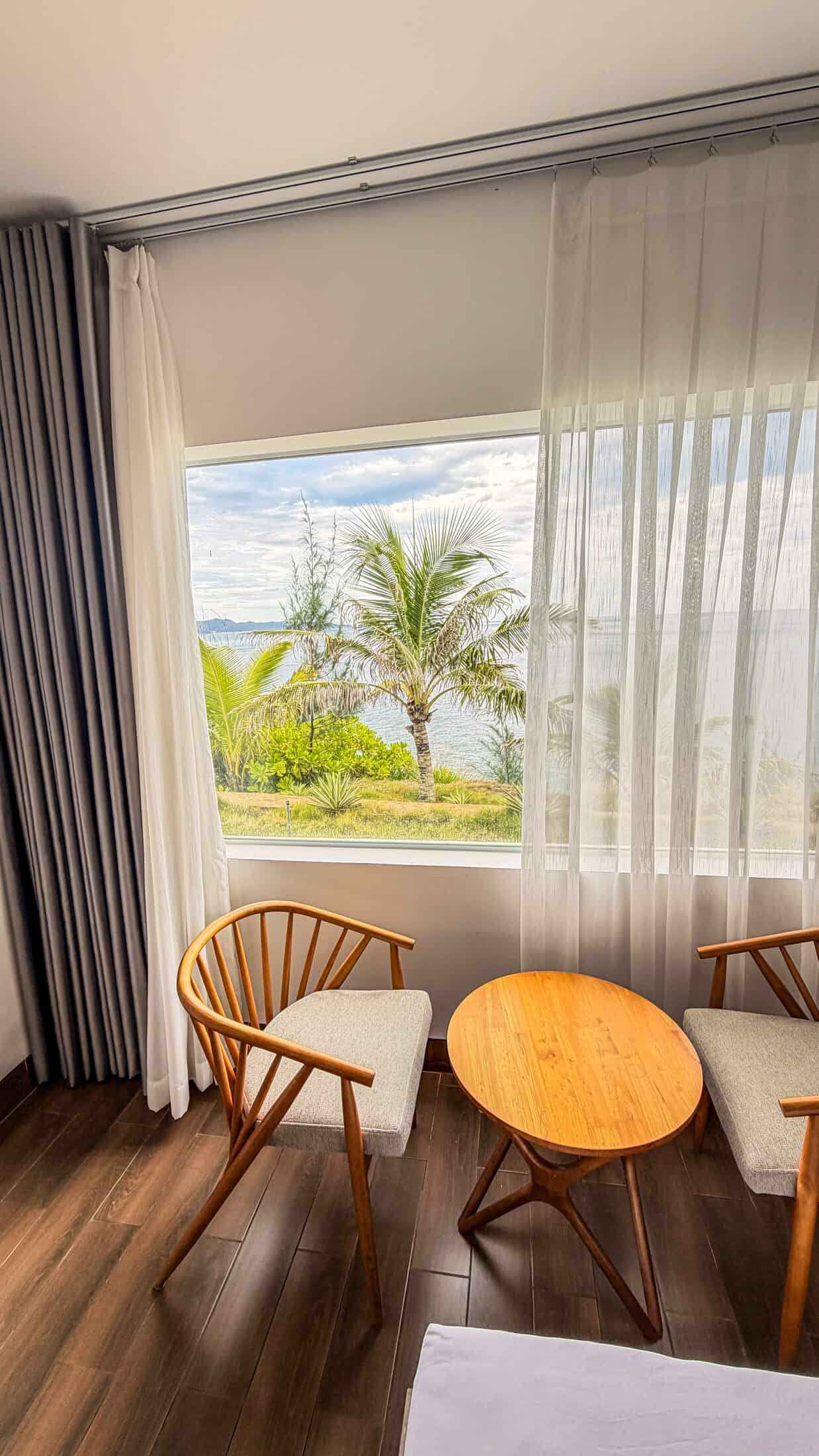 Window seating with a palm and sea view at La Costa Resort, Quy Nhon