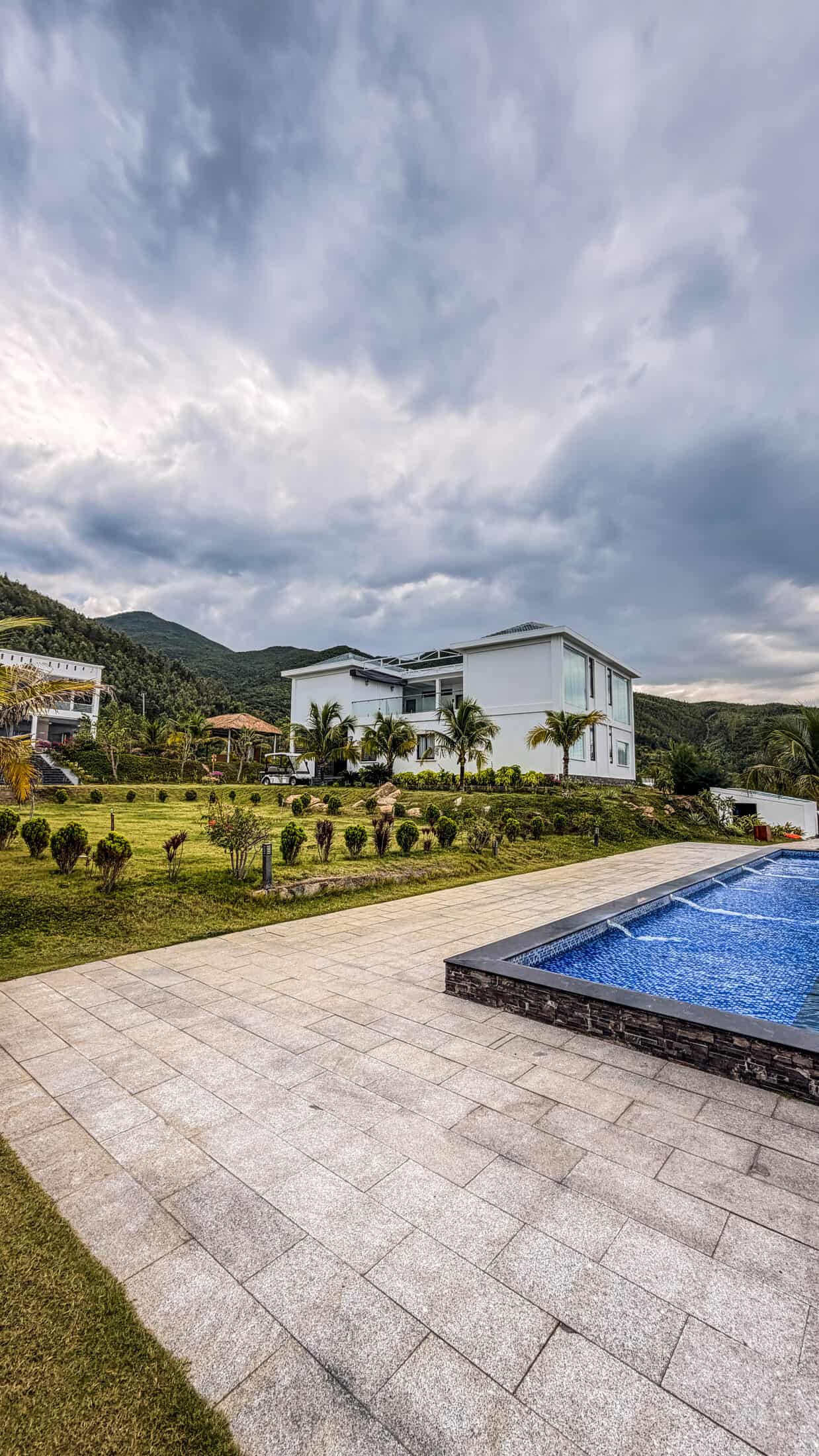 Hillside villa exterior and pool with mountain backdrop at La Costa Resort, Quy Nhon