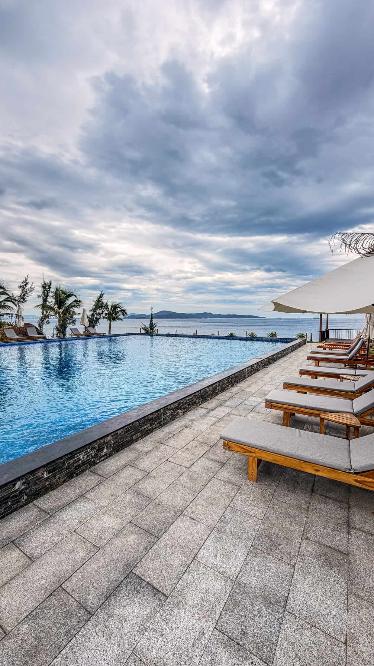 Infinity pool and loungers overlooking the bay at La Costa Resort, Quy Nhon