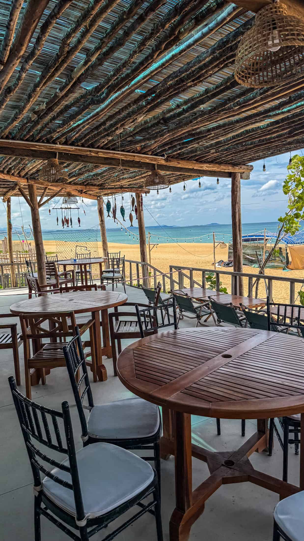 Thatched-roof dining terrace with sea view at Lumiere Beach Bistro in Tuy Hoa