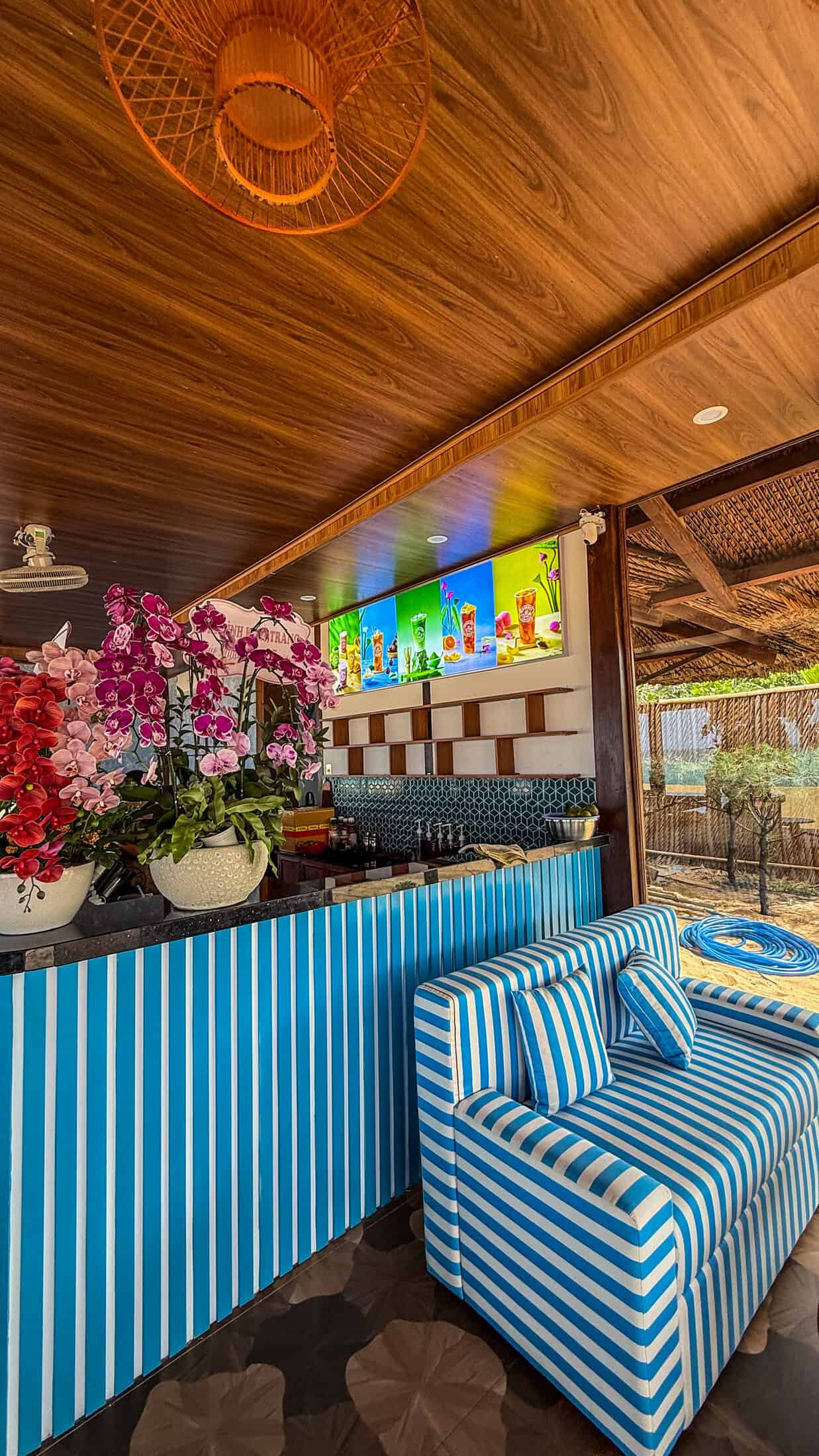 Striped blue bar counter with cocktail menu boards inside Ocean Kite Coffee