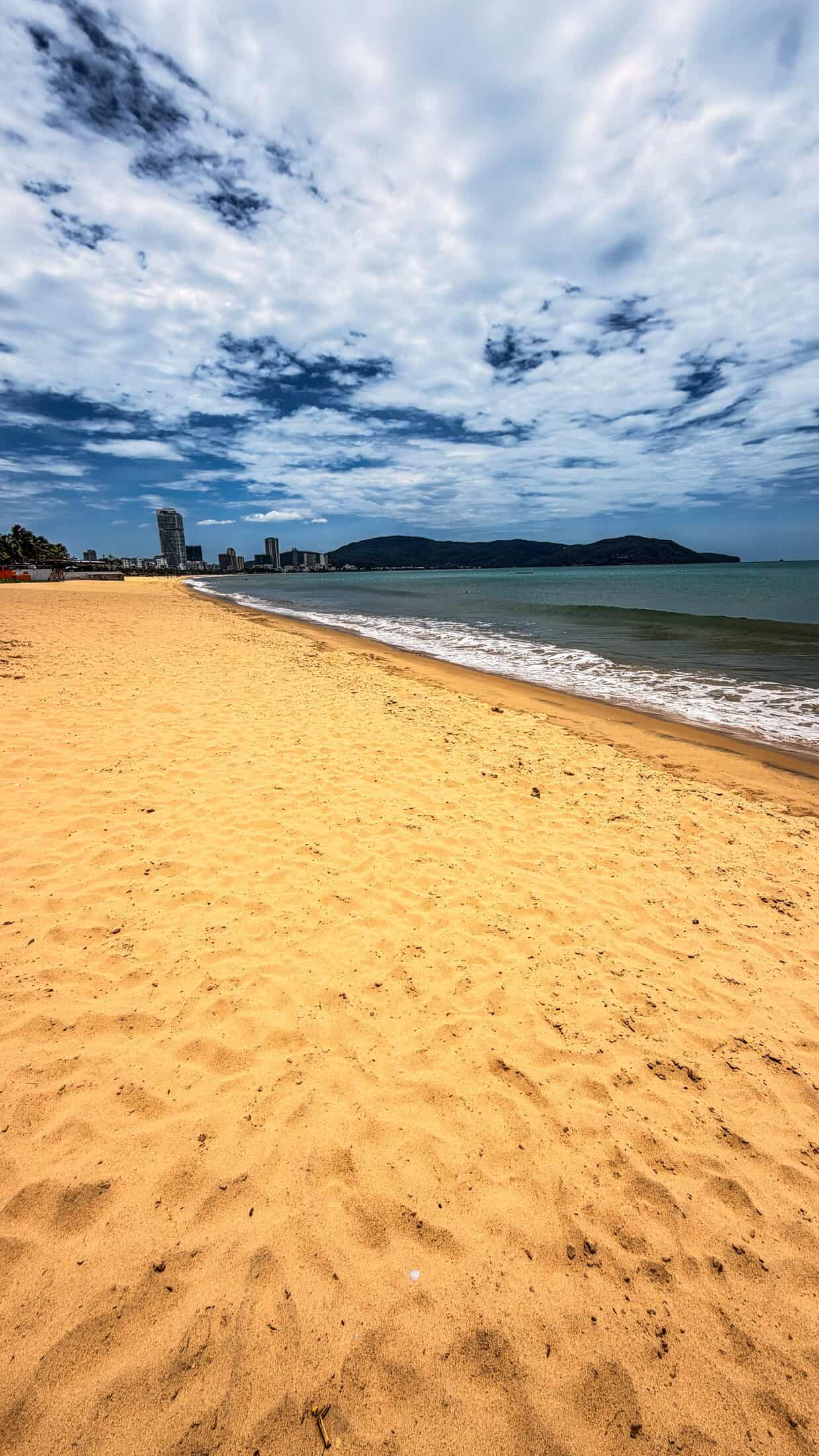Quy Nhon beach curving toward the city skyline and headland
