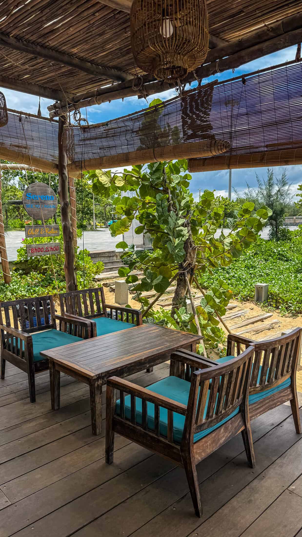 Teal-cushioned wooden armchairs under a thatched pergola at Sereno Beach, Tuy Hoa