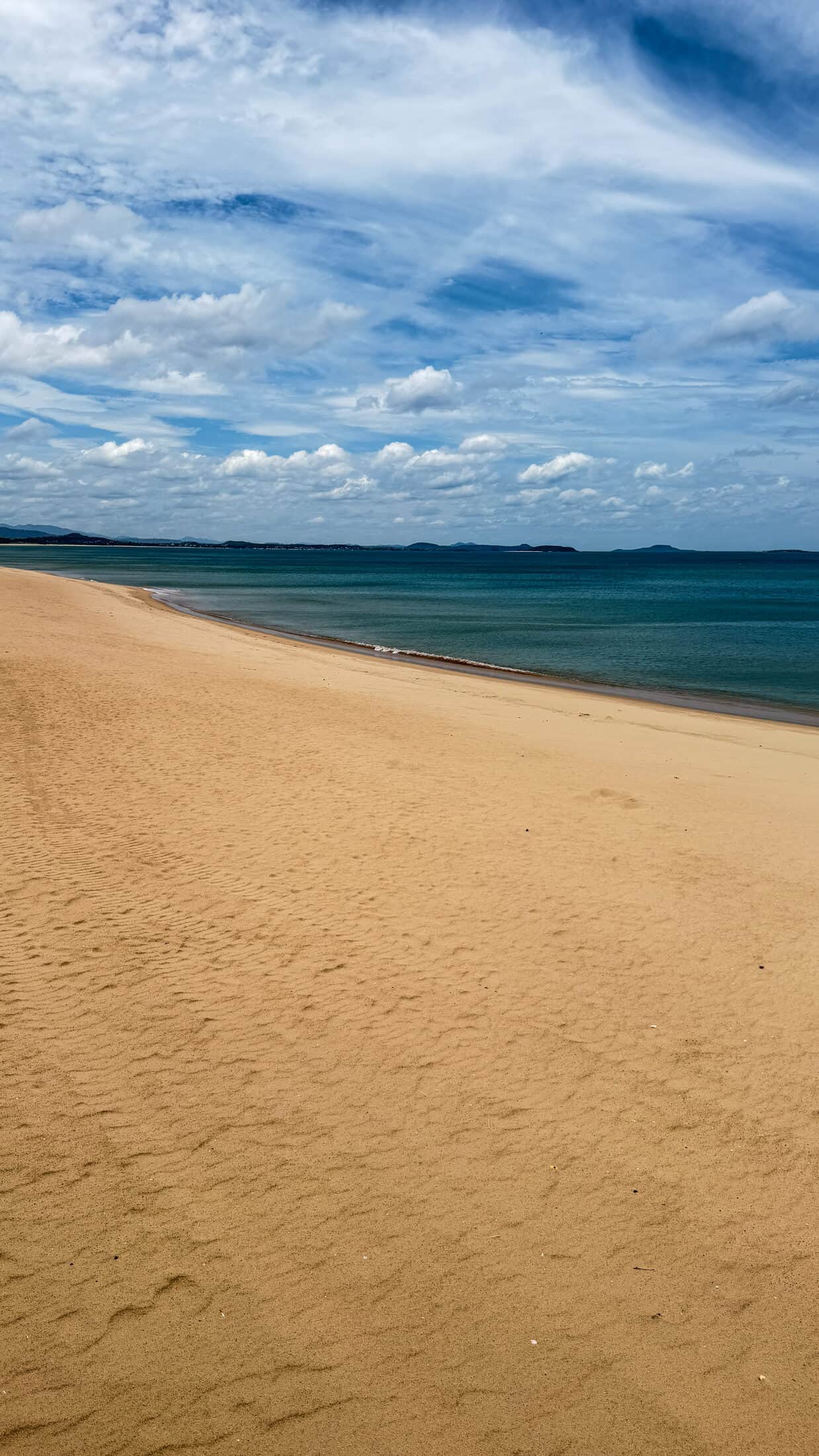 Wide empty stretch of golden sand curving along Tuy Hoa beach